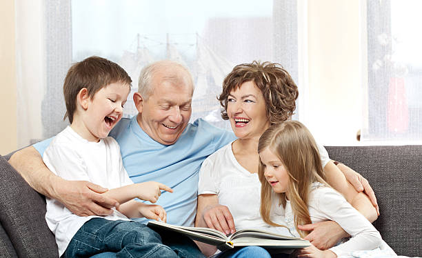 istock Grandparents with grandchildren reading book 157604303
