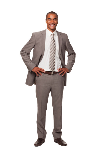 Full frame portrait of a young adult businessman with his hands on his hips, smiling at the camera. Isolated on white. Vertical shot.