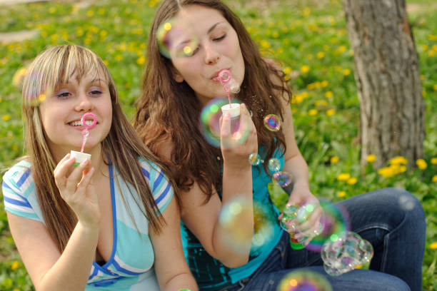 istock Young women sitting among spring flowers 157605632