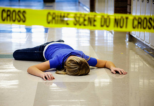 School Crime Scene A student lying in an empty school hallway behind crime scene tape. dead person photos stock pictures, royalty-free photos & images