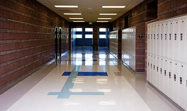 An empty school hallway lined with lockers.