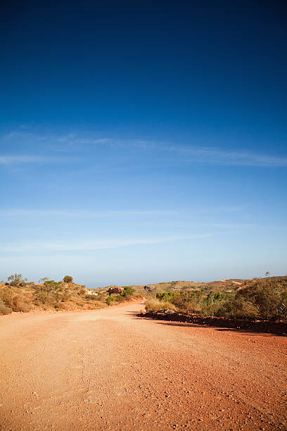 Dirt track leading into the Australian Outback country road through Australian outback. Red colored dirt road. Exmouth, Western Australia.  exmouth western australia photos stock pictures, royalty-free photos & images