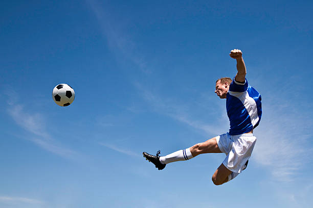 Young asian boy heading soccer ball