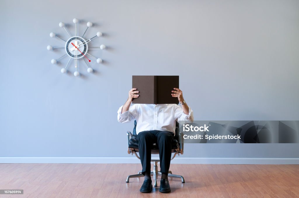 Homem lendo livro em quarto vazio - Foto de stock de Escritório royalty-free