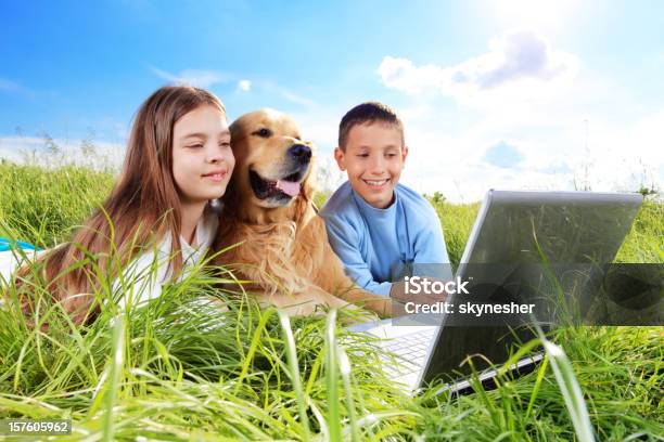 Bambini Con Il Cane Sul Prato A Riposo - Fotografie stock e altre immagini di Accudire - Accudire, Allegro, Ambientazione esterna