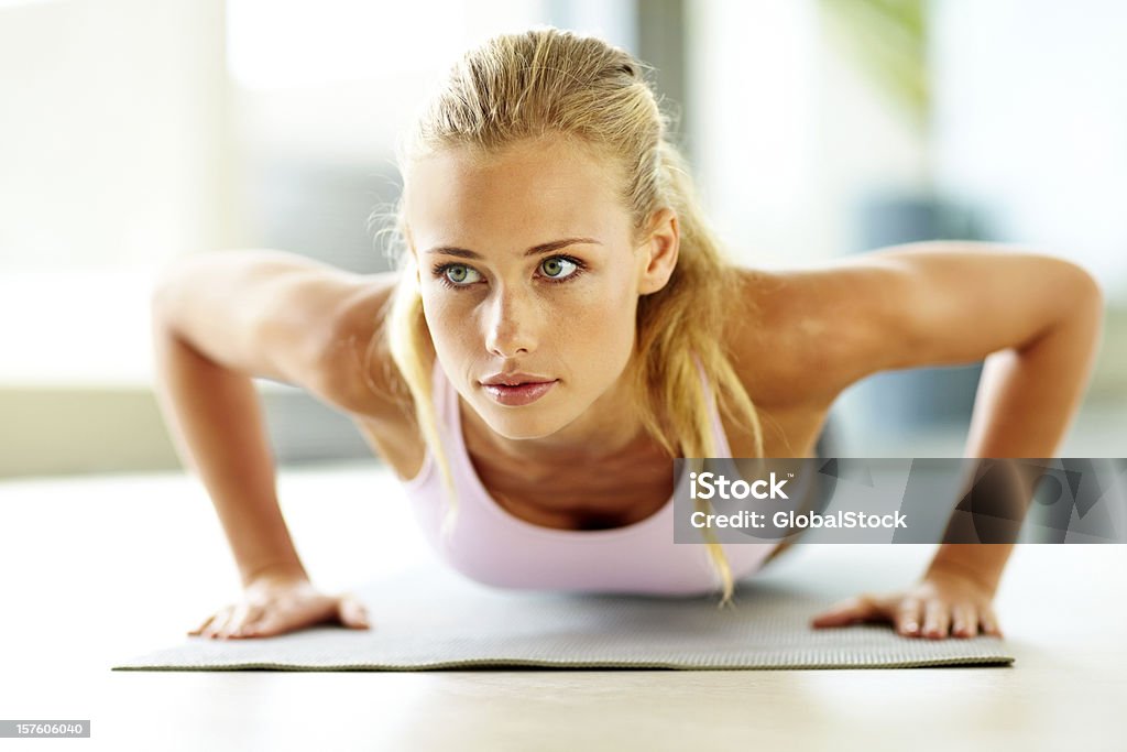 Attraente giovane donna facendo push up sul Materassino ginnico - Foto stock royalty-free di 20-24 anni