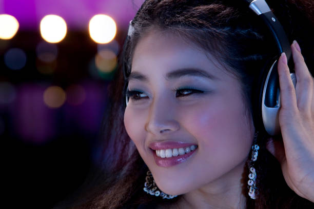Happy Asian female - listening to music intensely