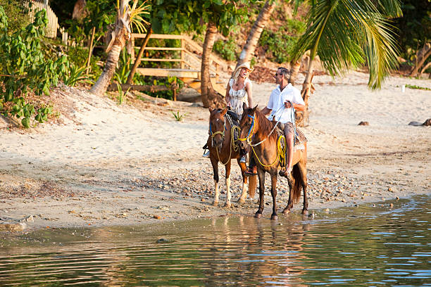 istock Couple enjoying horseback ride on the beach 157606312