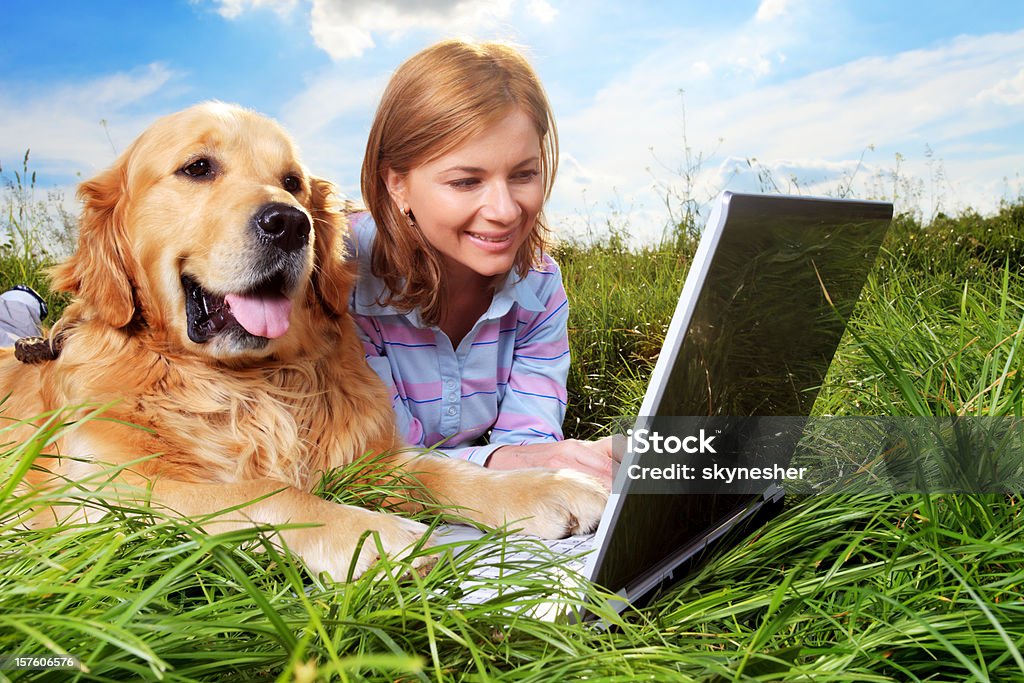 Женщина и собака, отдых, набрав на ноутбуке. - Стоковые фото Весна роялти-фри