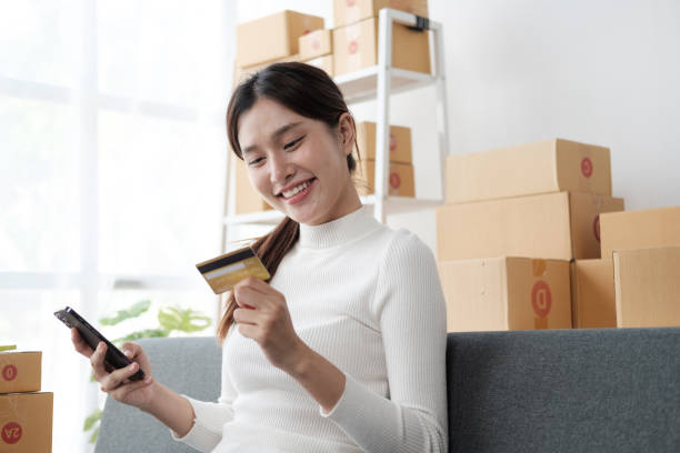 istock Young female entrepreneur working with laptop computer and using credit card at home. 1576066293