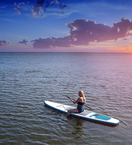 istock Young attractive woman posing on paddle board 1576068596