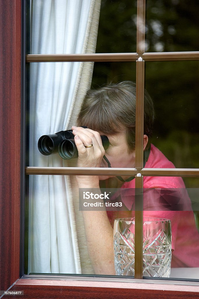 Nosey vicino alla finestra con Binocolo - Foto stock royalty-free di Adulto