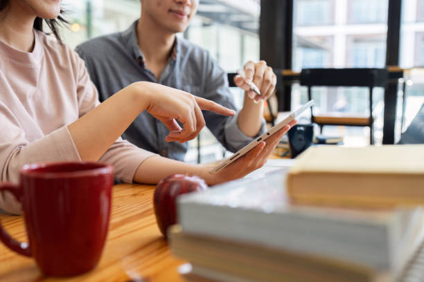 istock Two Asian students learning together with a laptop and tutor together at cafe 1576070204