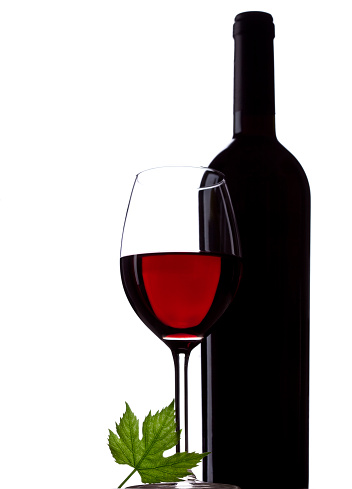 bottle, glass with wine and vine leaf on white background