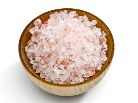 Salt crystals for cooking the food. Pile of sea salt on a black natural background.