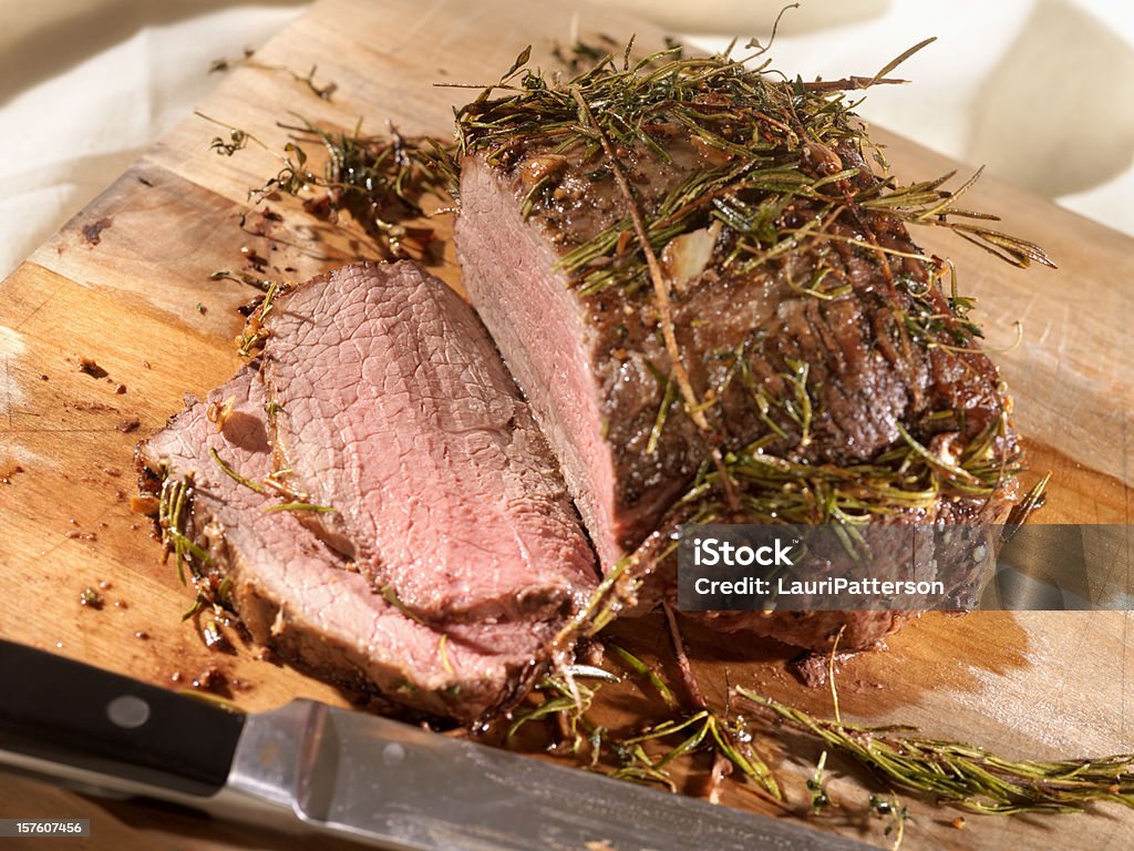 Carne de res asada con romero en una tabla de cortar - Foto de stock de Rosbif libre de derechos