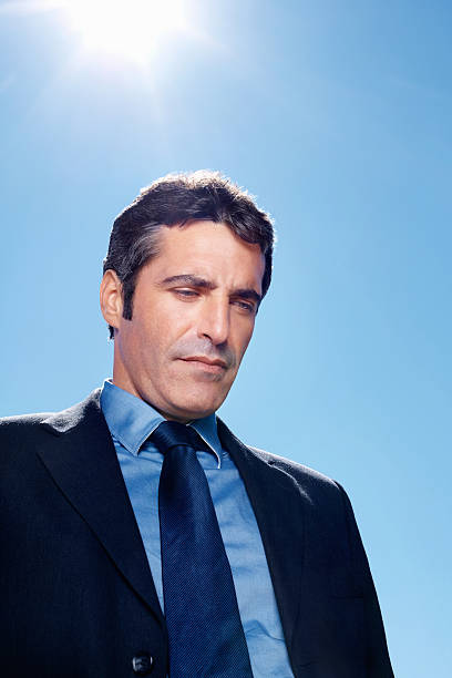 istock Tensed business man against clear blue sky 157608132