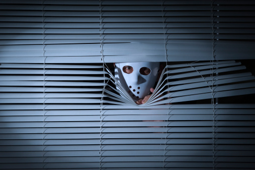 Spooky men with mask behind blinds.