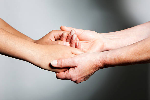 istock hands: young and old hands holding and supporting each other 157608423