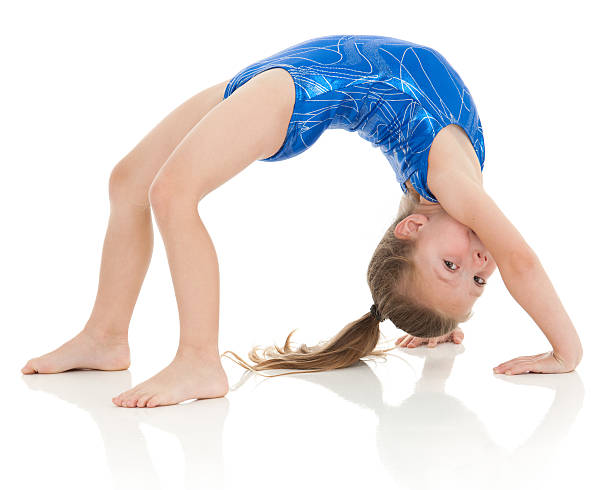 Little gymnast doing in a bridge exercise, eyes on viewer  bending over backwards stock pictures, royalty-free photos & images