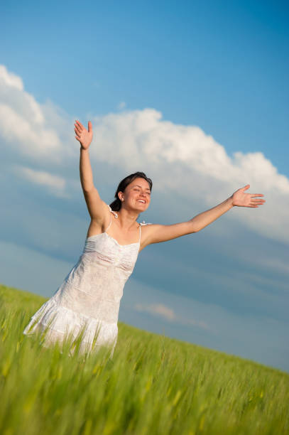 istock Happy Young Woman with arms stretched to sky 157608515