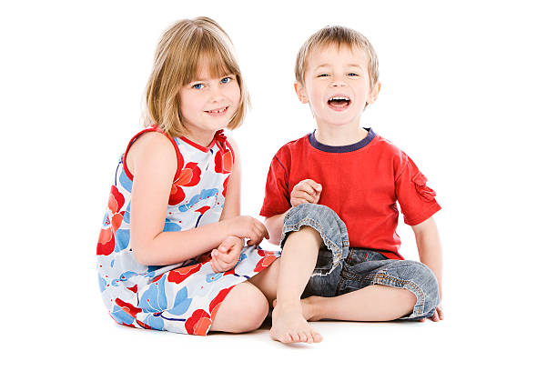 istock Young boy and girl sitting back to back on white 157608552