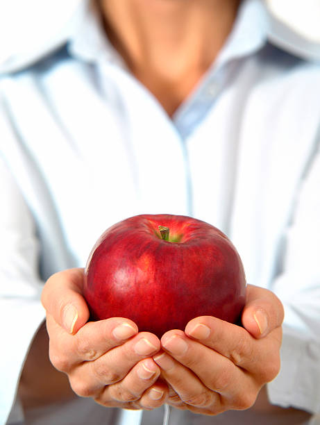 istock Woman is holding red apple in hands, focus on apple 157608587