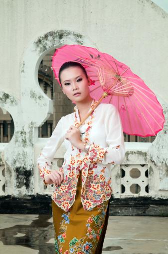 'Baba Nyonya' is a mixture of the chinese and malay culture during the 15th to 16th century in Nusantara, especially Malacca. Photo shown is a chinese fashion model wearing baba nyonya costume, known as 'baju kebaya', with a traditional umbrella.