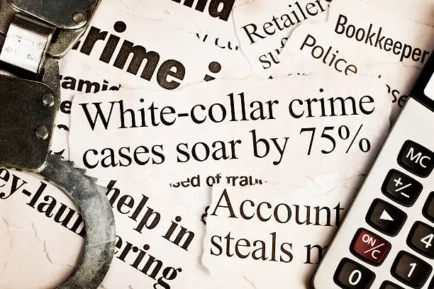 Photo of Handcuffs and calculator on headlines about white collar crime