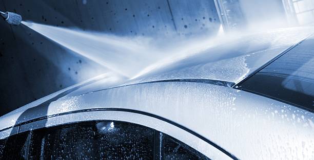 auto waschen mit einem wasserstrahl auf autowäsche service - washing water car cleaning stock-fotos und bilder