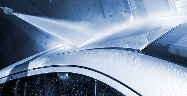 Car wash - with a water jet at carwash service Washing car by a water jet at a carwash service power in nature stock pictures, royalty-free photos & images