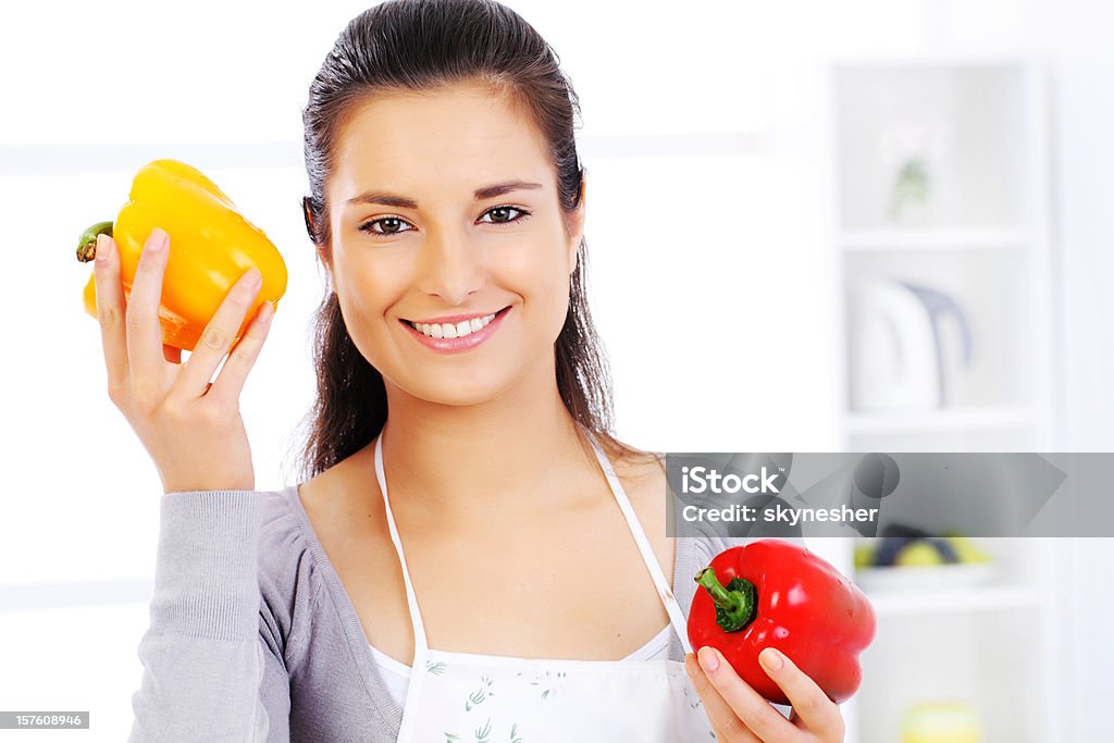 Jeune femme souriante tenant des poivrons rouge et jaune. - Photo de Adulte libre de droits