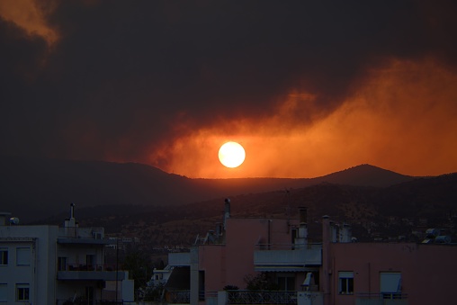 Thick smoke from a fire at sunset, large fire near the city of Volos, Greece