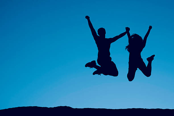 istock Silhouette of a Jumping Couple 157609143