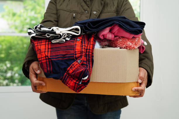 istock Clothes donations in cardboard box for volunteer. 1576095765