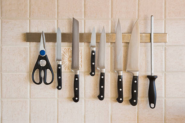 Kitchen knives magnetized on the backsplash Kitchen knives on a magnetic rack kitchen knife stock pictures, royalty-free photos & images