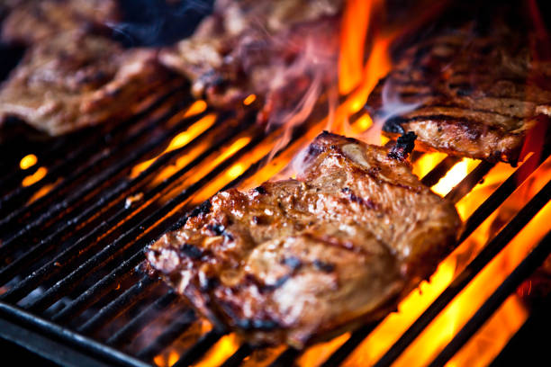 istock Pork chops cooking on a grill over flames 157609658