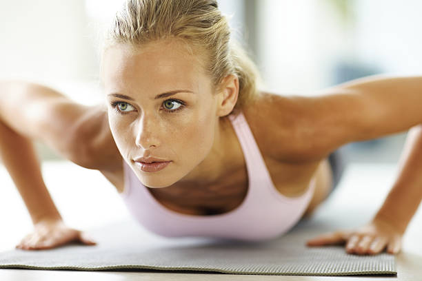 Attractive young lady doing push ups on exercise mat  blonde female bodybuilders stock pictures, royalty-free photos & images