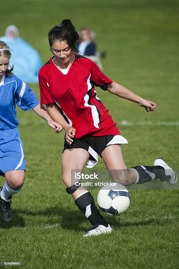 Jugador de fútbol femenino controles saltando de bola - Foto de stock de Empujar libre de derechos