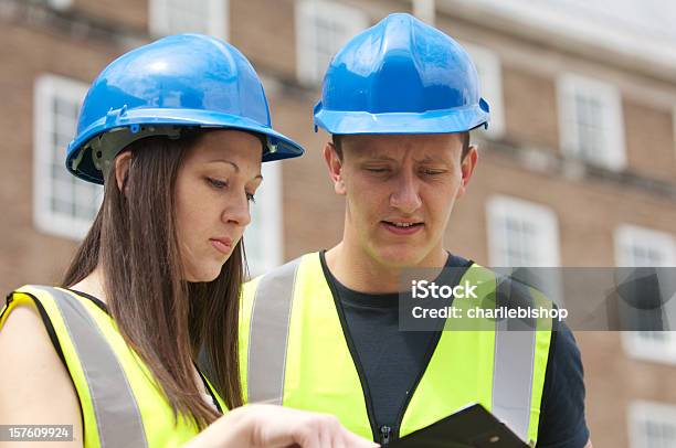 Foto de Homens E Mulheres Jovens Engenheiros De Construção e mais fotos de stock de Adulto - Adulto, Amarelo, Artigo de vestuário para cabeça