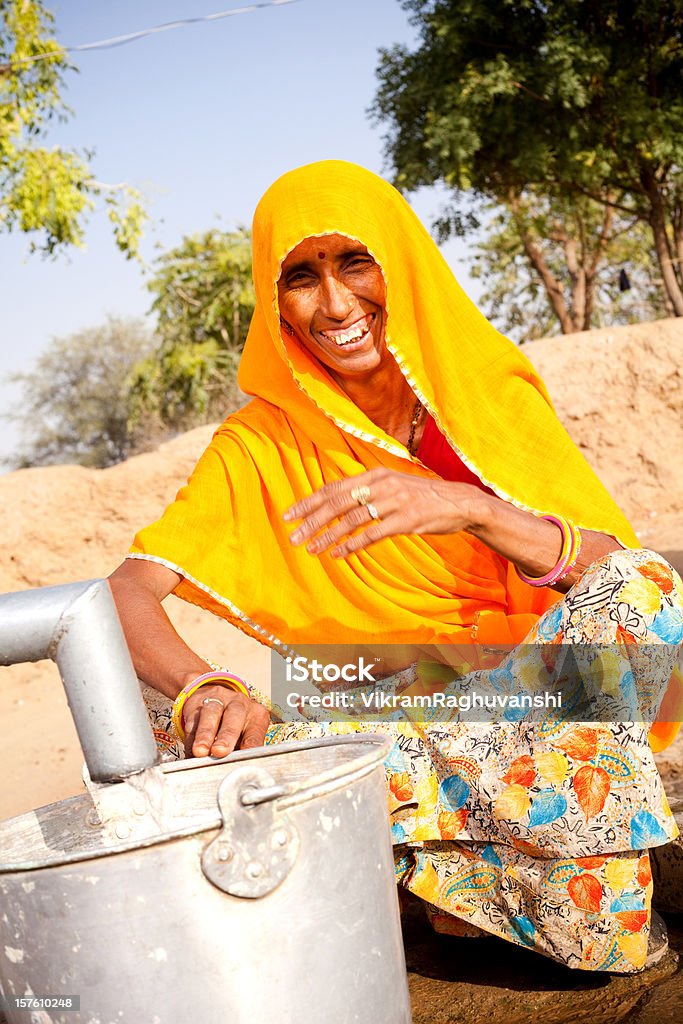 伝統的なインドの田舎の女性水で魅力的なラジャスタン州 - インドのロイヤリティフリーストックフォト