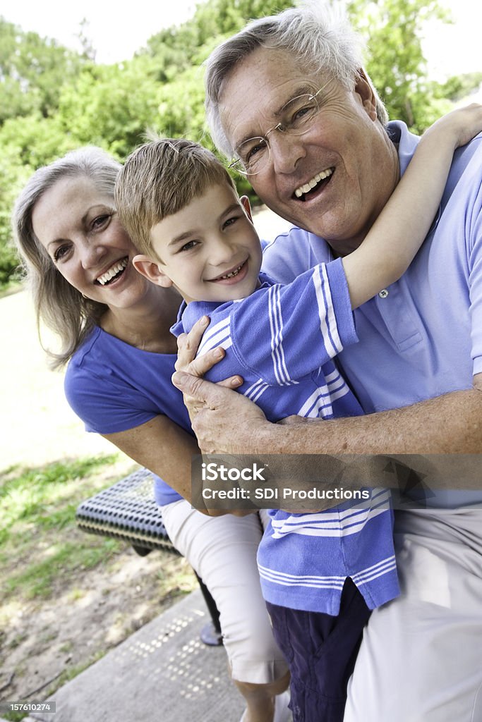 Feliz abuelos al aire libre, con su nieto - Foto de stock de Abrazar libre de derechos