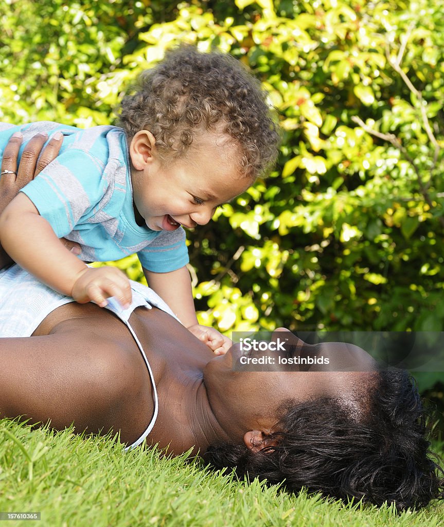 African American interagire con un bambino nel parco - Foto stock royalty-free di 12-17 mesi