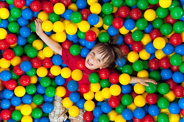 Smiling child playing in a colorful ball pit Children on the balls kid in ball pit stock pictures, royalty-free photos & images