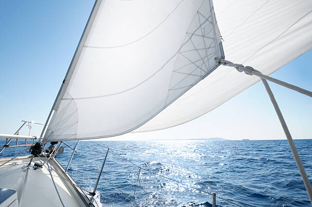 Boat under sail on a sunny day White sails of a yacht billowing in the wind, French Riviera. jib stock pictures, royalty-free photos & images