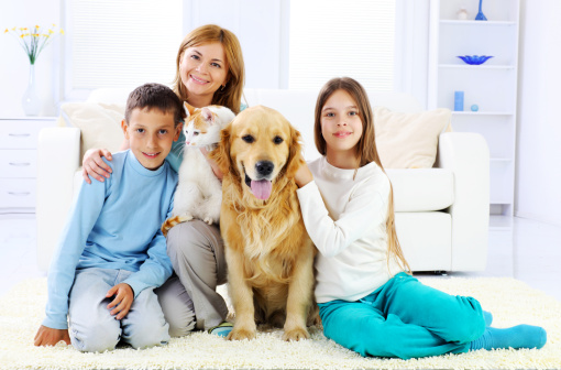 Children with mother and them cute pets resting in the home.