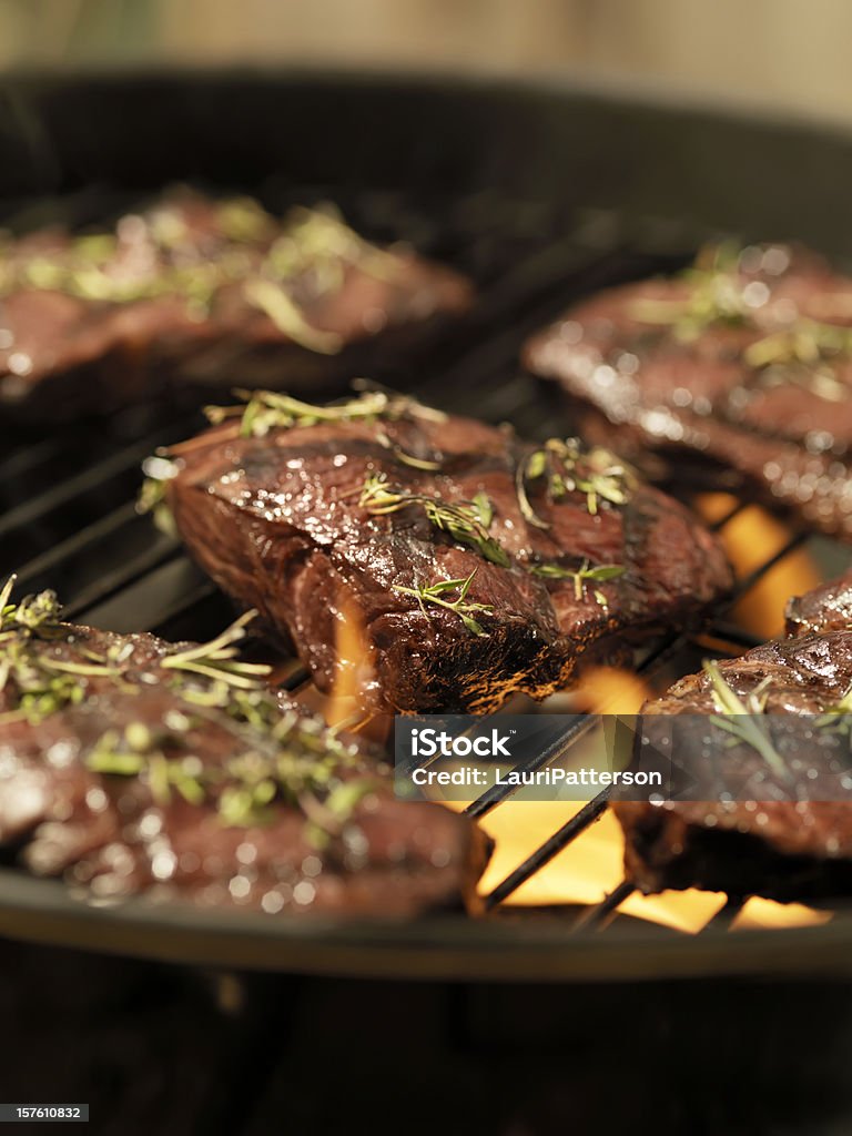 Controfiletto bistecca con erbe aromatiche fresche su un barbecue all'aperto - Foto stock royalty-free di Al sangue