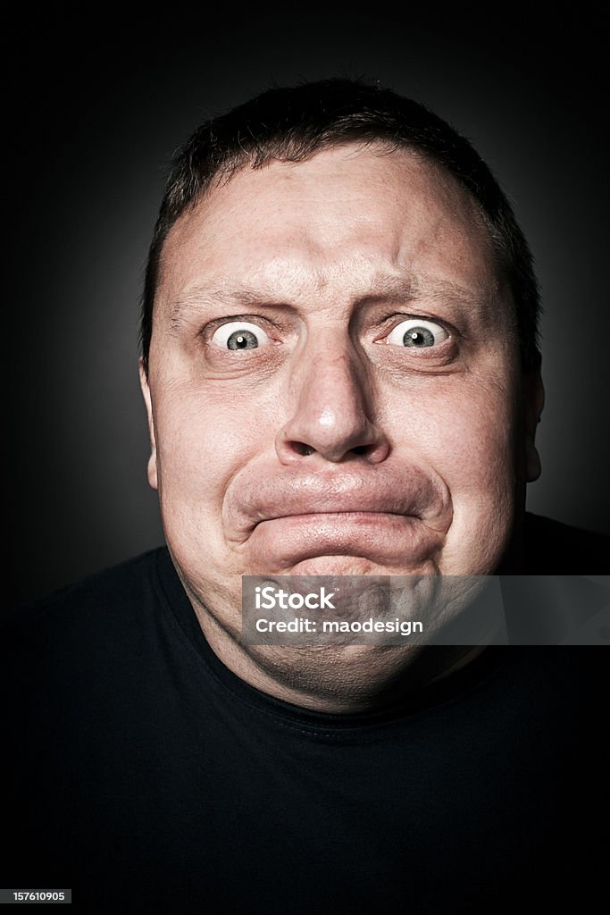 Uomo di mezza età tenendo indietro rabbia, ritratto in Studio - Foto stock royalty-free di Trattenere