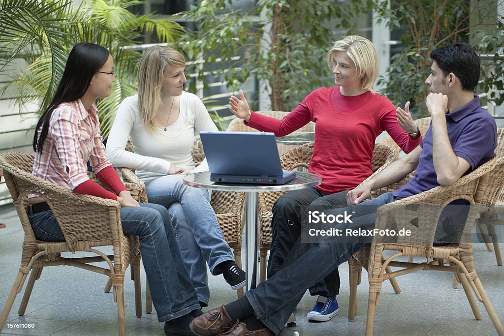 Grupo de quatro multi-étnica alunos em colaboração com o laptop apresentação - Foto de stock de Adulto royalty-free
