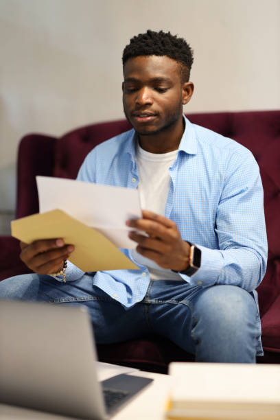 istock Young black man looking through financial information. 1576110959